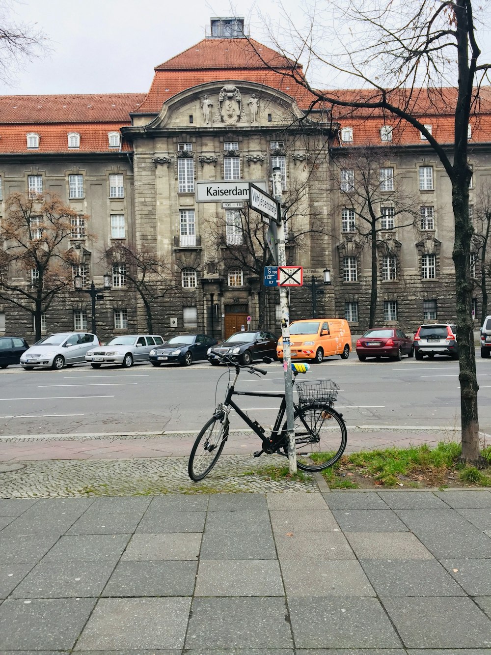 a bike parked on the side of a street next to a tree