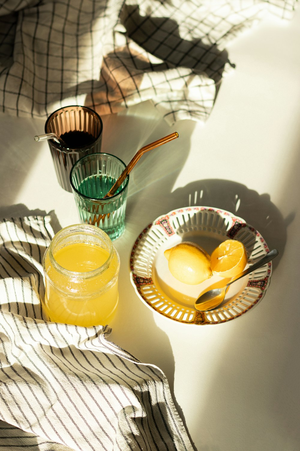 a bowl of lemons and a glass of juice on a table