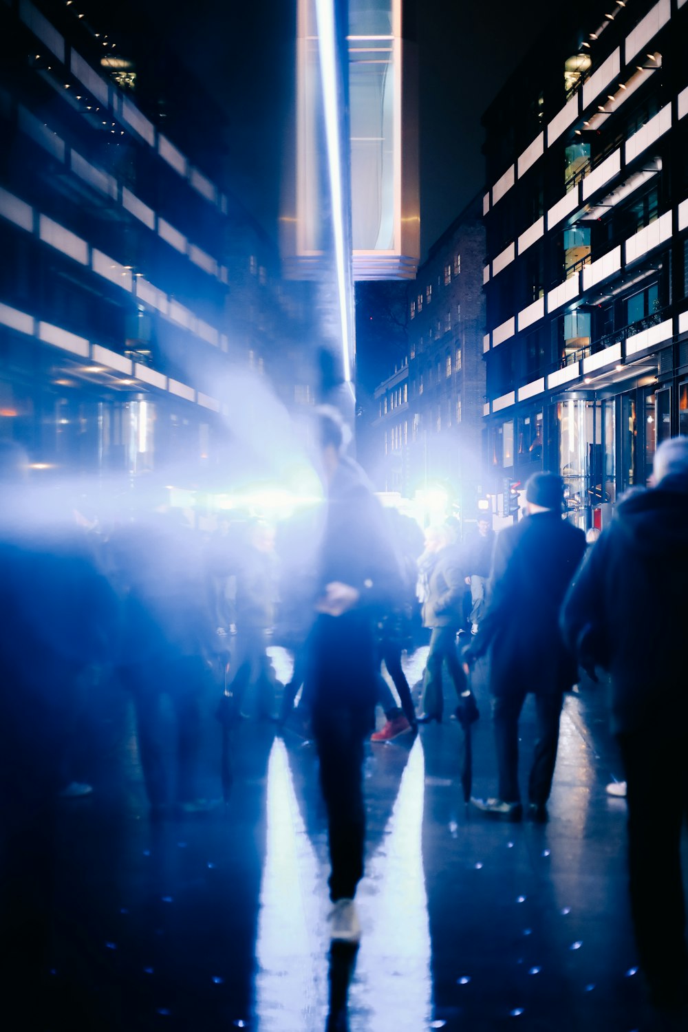 a group of people walking down a street at night