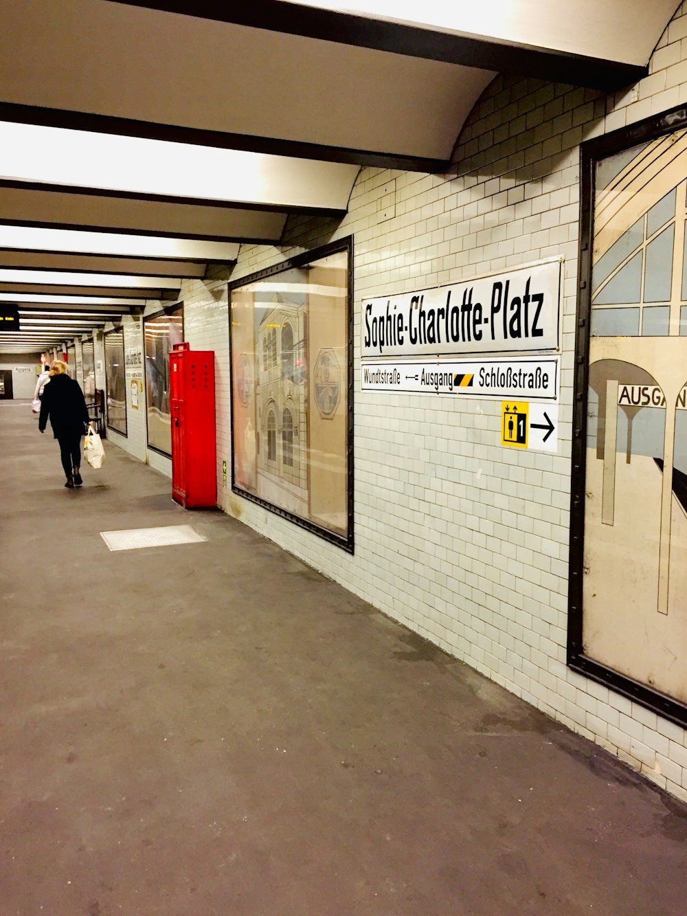 a subway station with a man walking down the platform