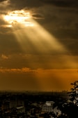 the sun is shining through the clouds over a city