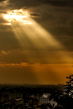 the sun is shining through the clouds over a city