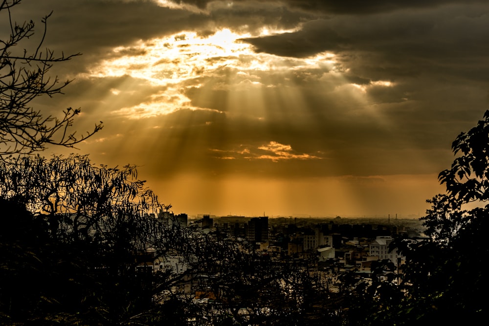 the sun shines through the clouds over a city