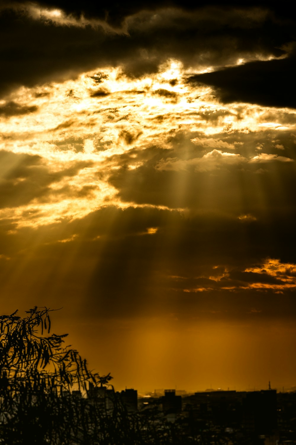 the sun is shining through the clouds over a city