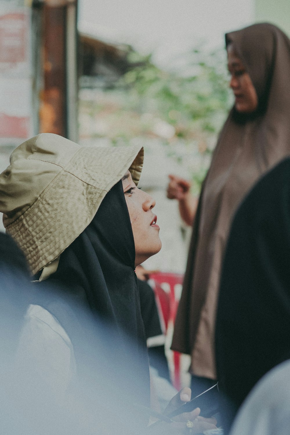 a woman in a hijab standing next to another woman