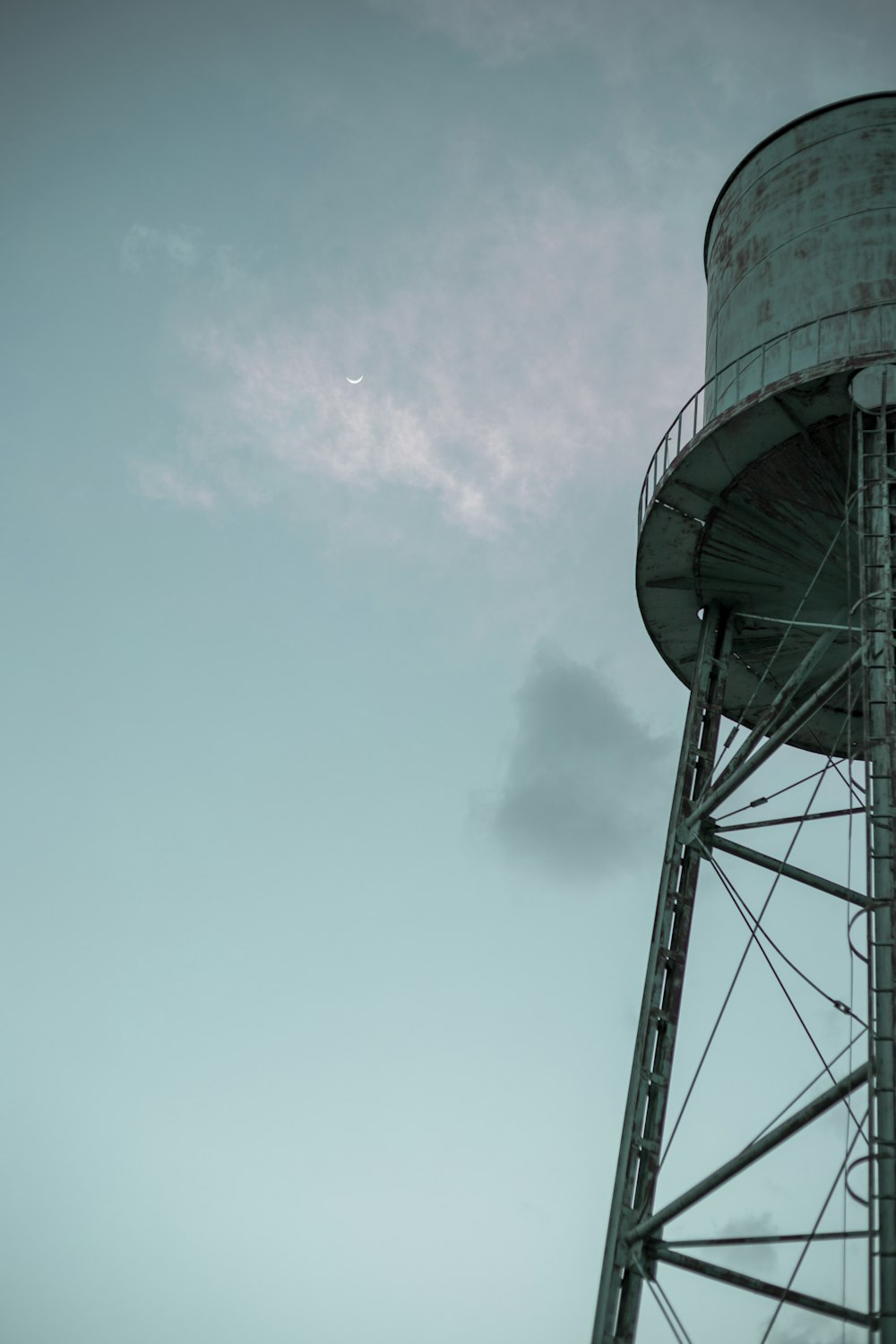 a water tower with a plane flying in the sky