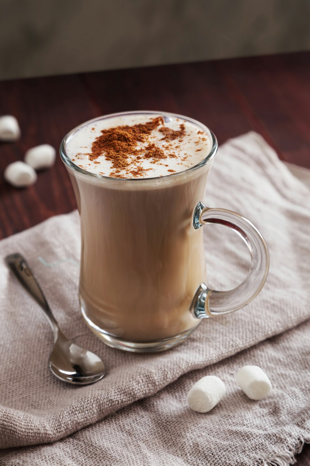 a cup of hot chocolate and marshmallows on a napkin