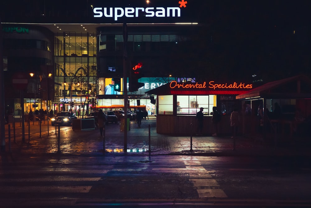 a city street at night with a neon sign