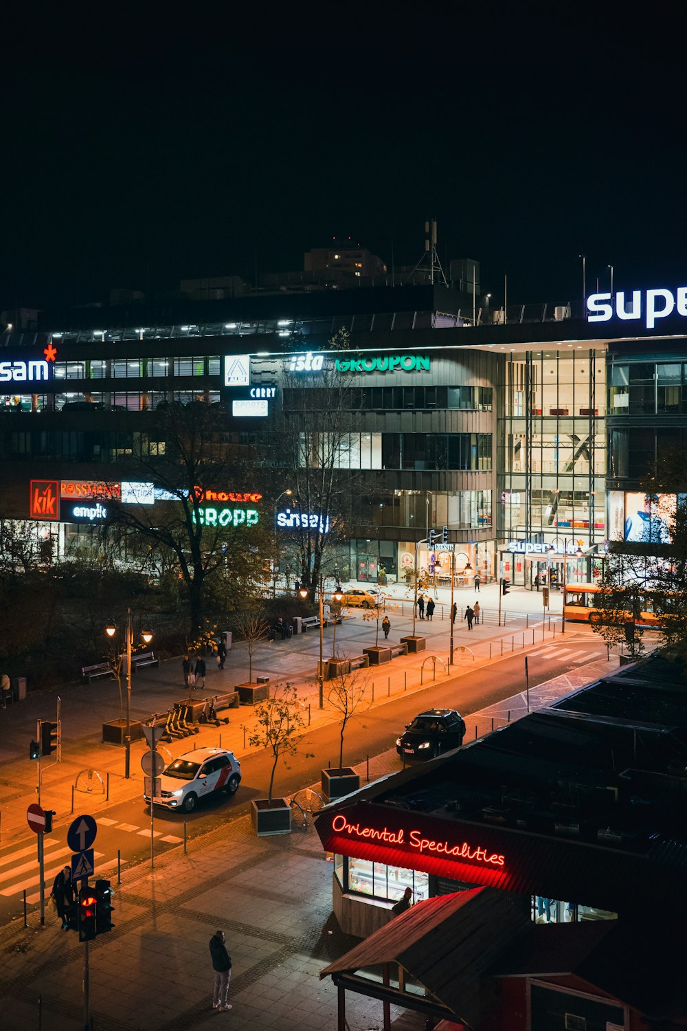 a city street at night with a large building in the background