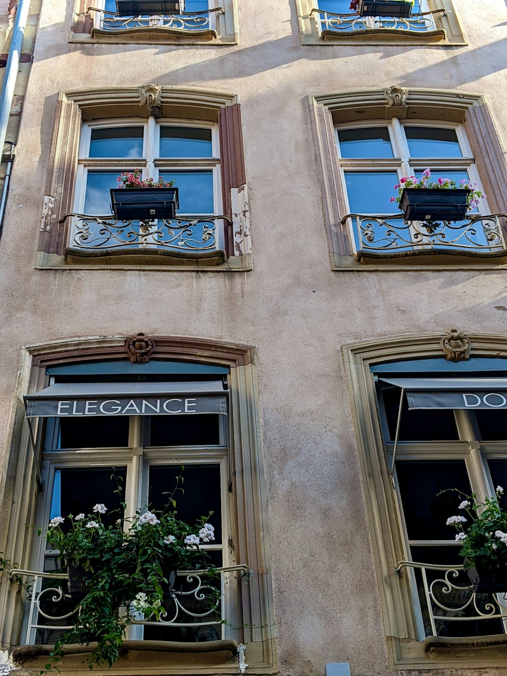 a tall building with many windows and flowers in them