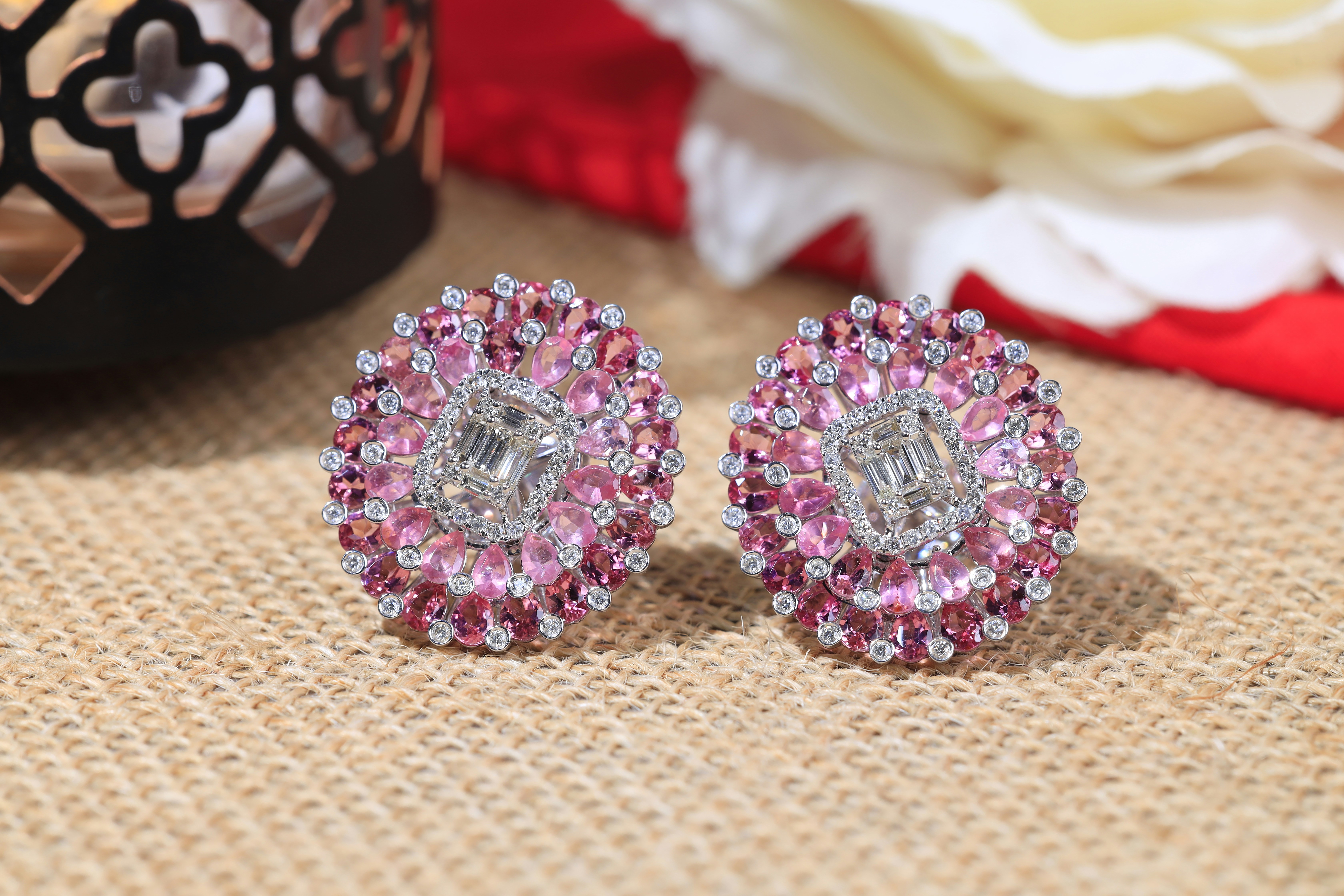a pair of pink and white earrings sitting on top of a table