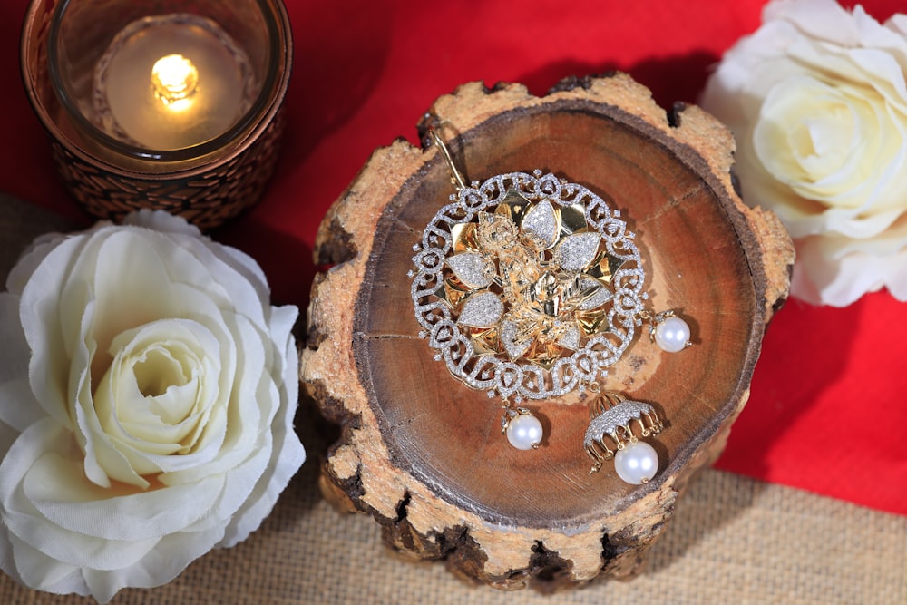 a wooden bowl with a ring on it next to flowers