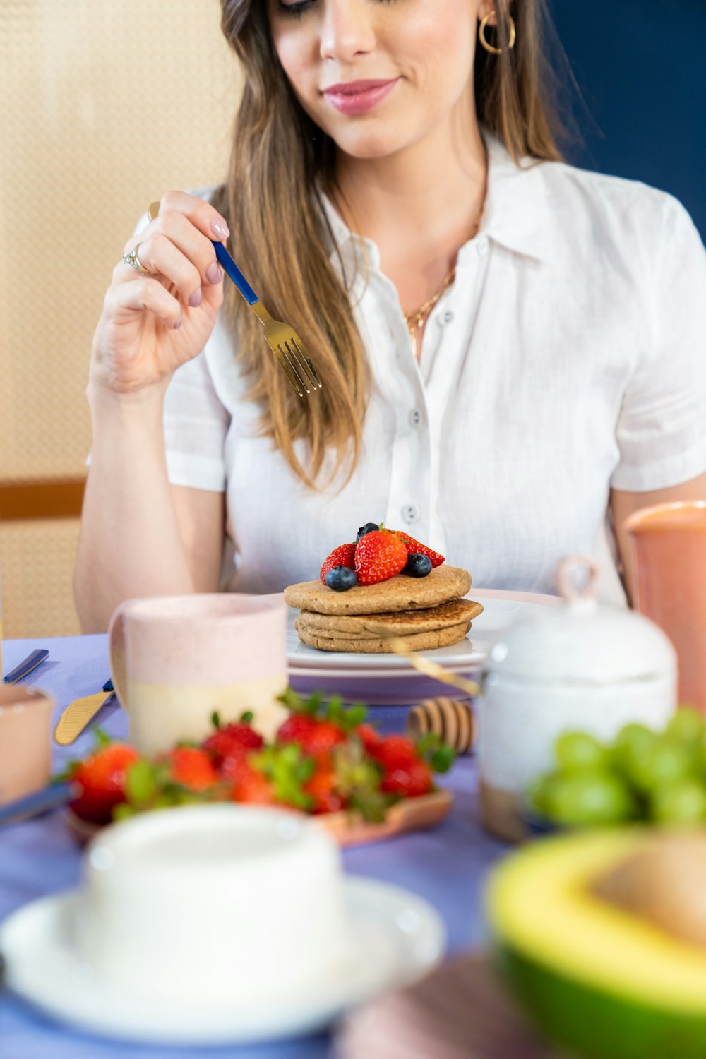 une femme assise à une table avec une assiette de nourriture