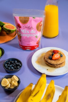 a table topped with plates of food and bananas