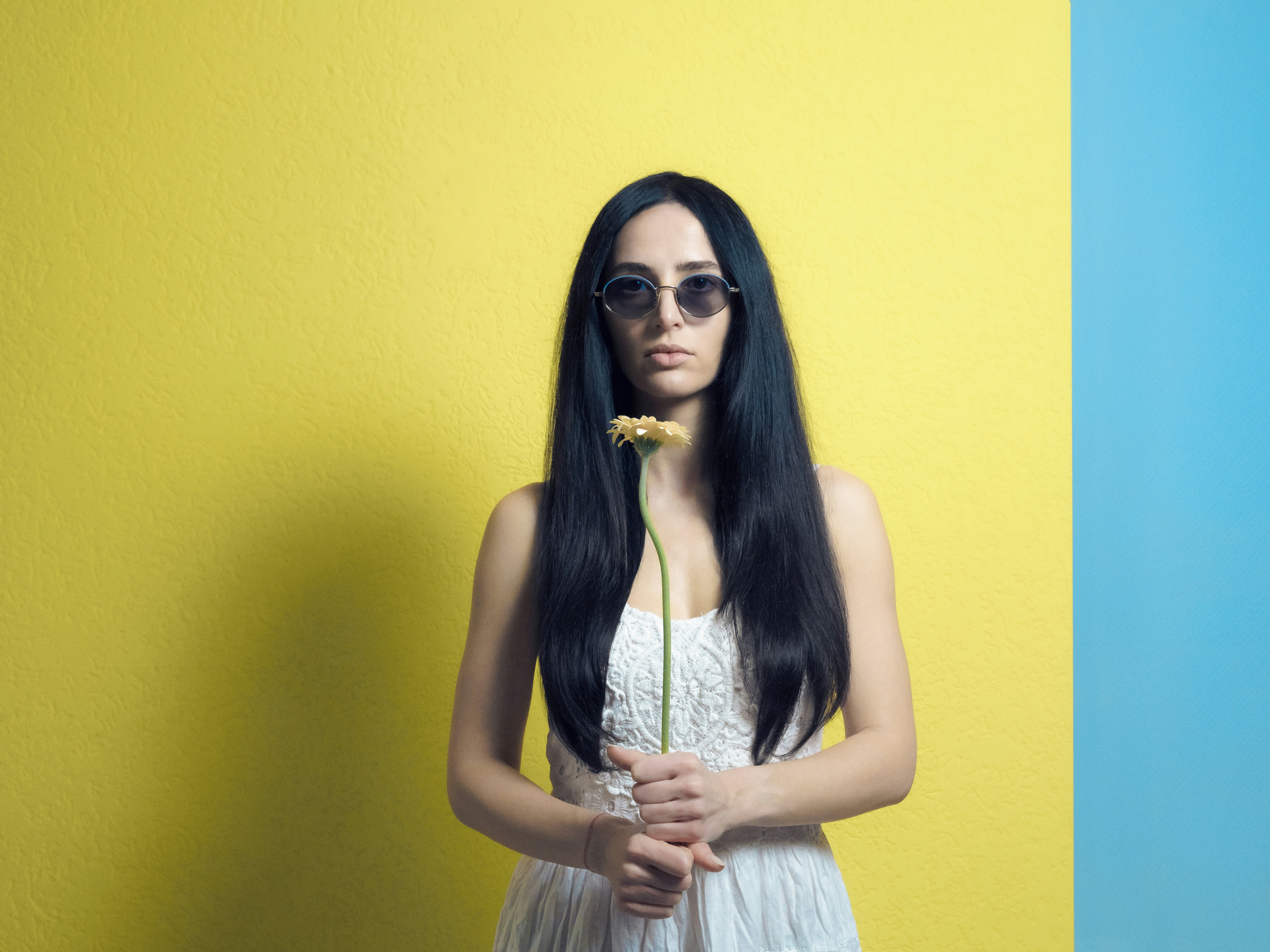 a woman with long black hair holding a flower