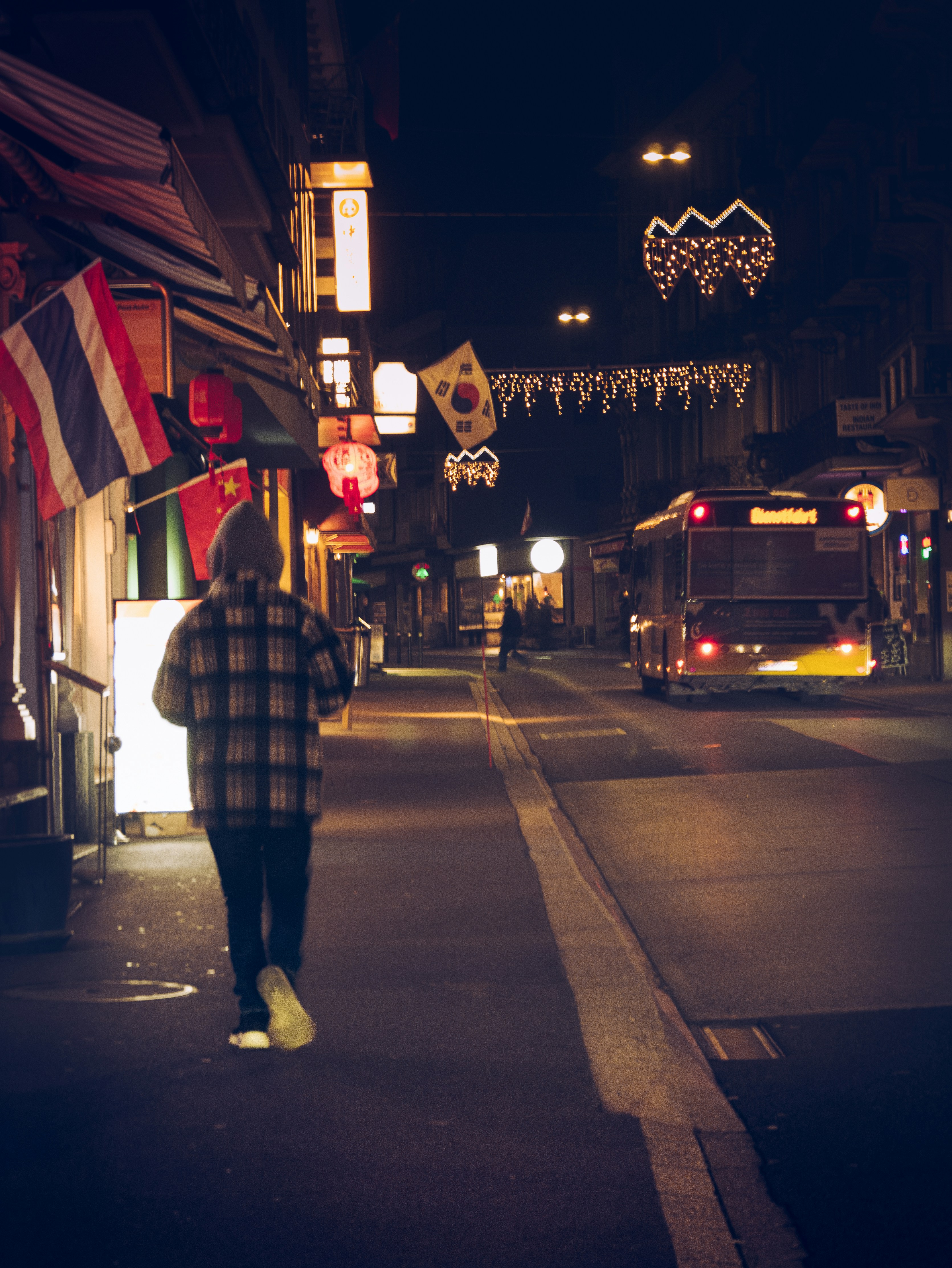 a person walking down a street at night