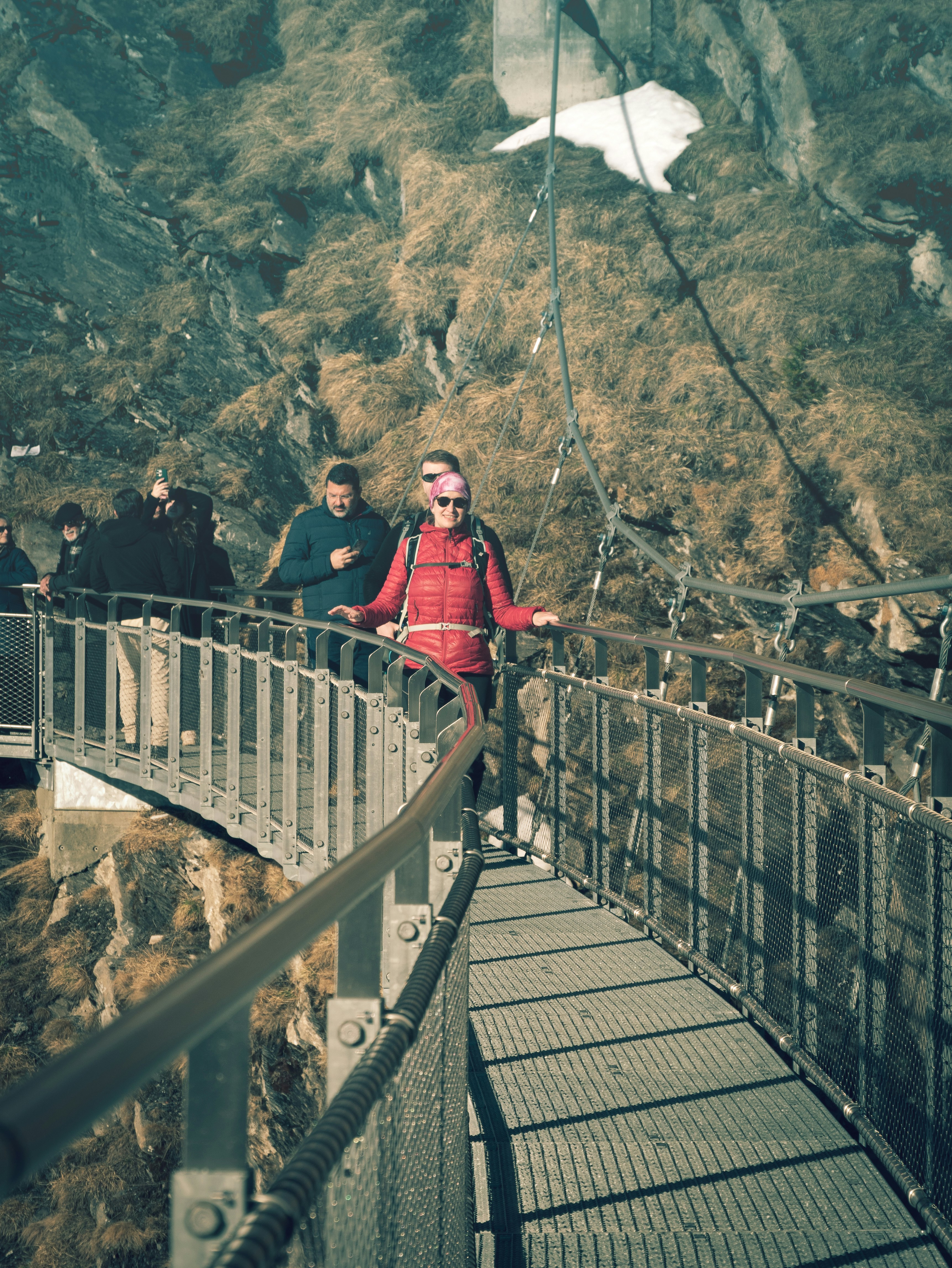 a group of people walking across a bridge
