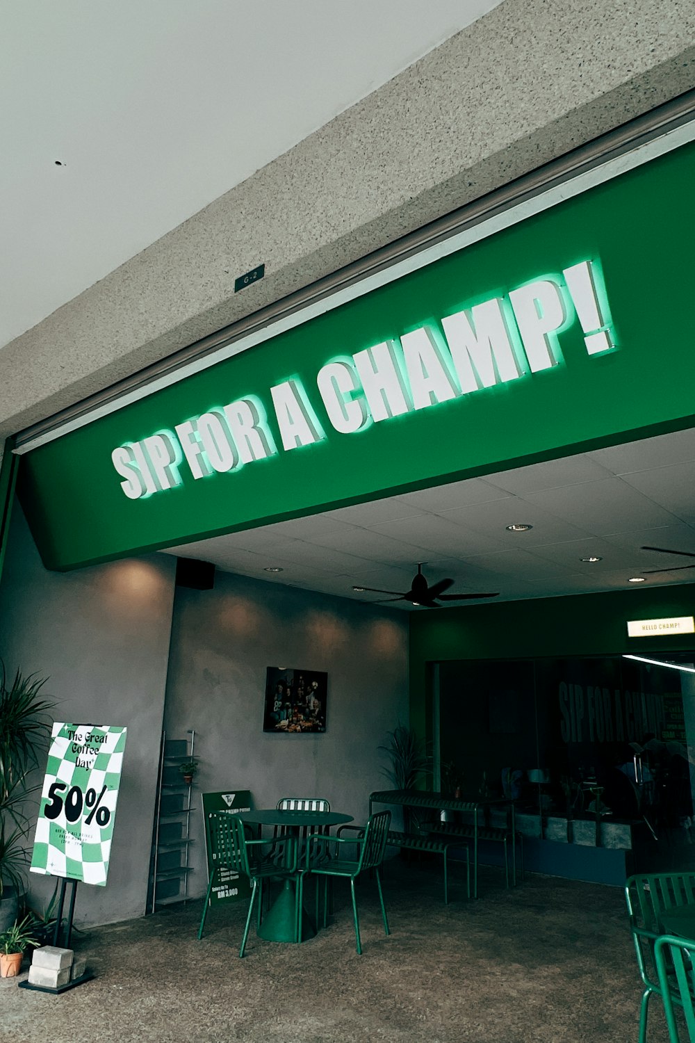 a green sign that says sippor a champ on the front of a building