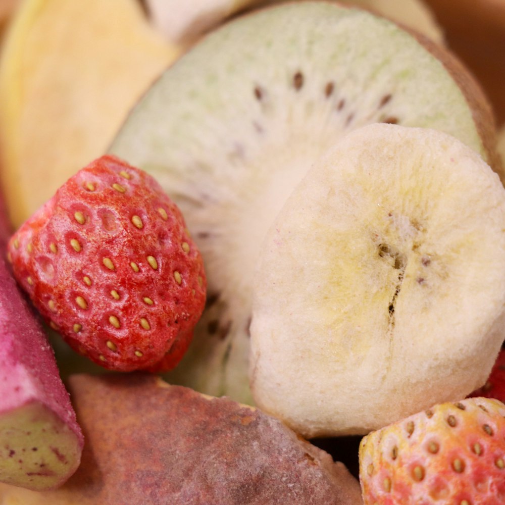 a close up of a banana, strawberry, and kiwi
