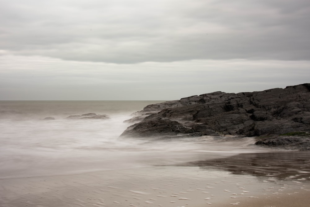 a rocky beach with waves coming in and out of the water