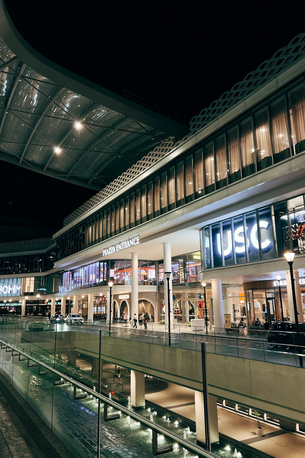 a shopping mall at night with people walking around