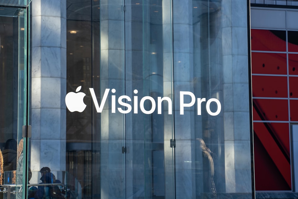 O logotipo do Apple Vision Pro é refletido no vidro de um prédio
