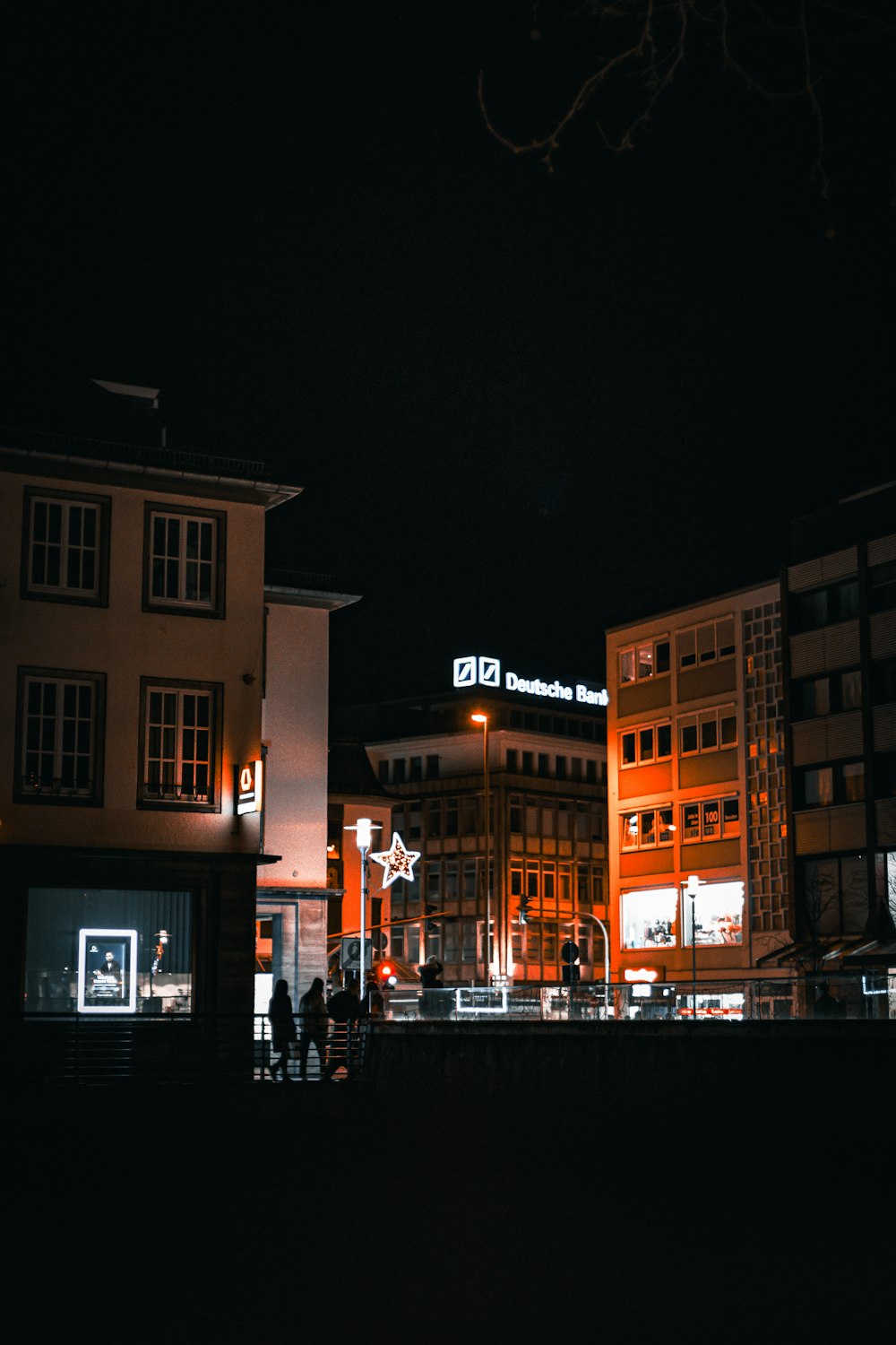 a group of people walking around a city at night