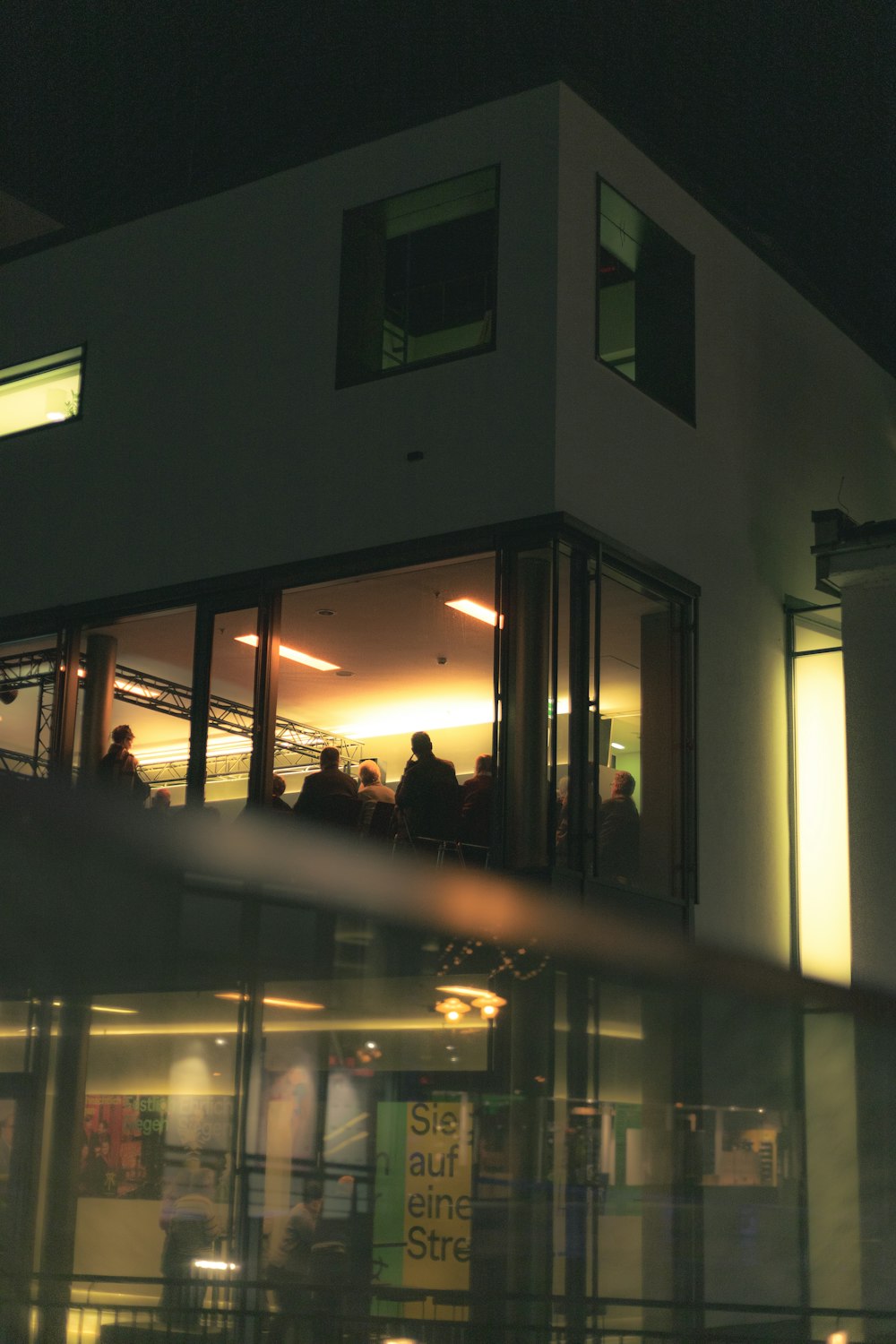 a group of people standing outside of a building at night