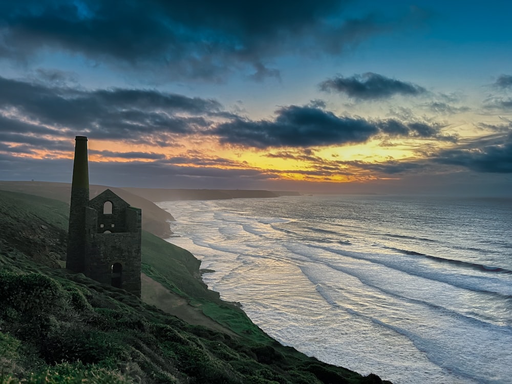 a tower on a hill overlooking the ocean