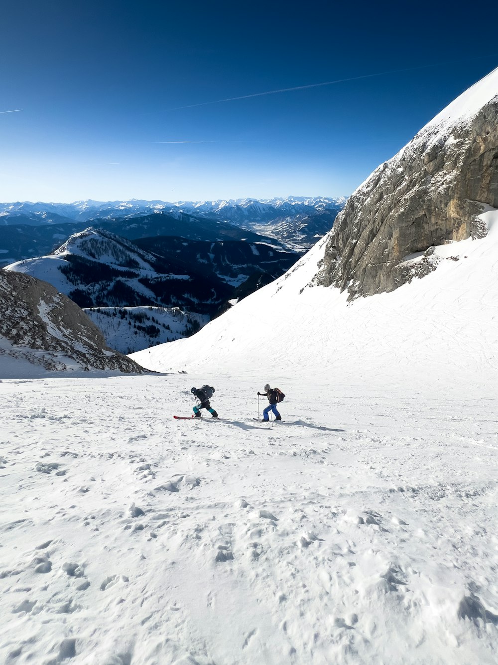 스키를 타고 눈 덮인 슬로프를 내려가는 두 사람