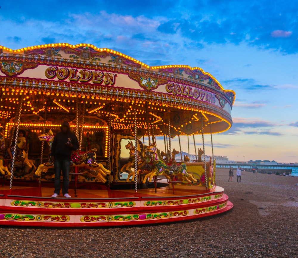 a man standing on a merry go round at the beach