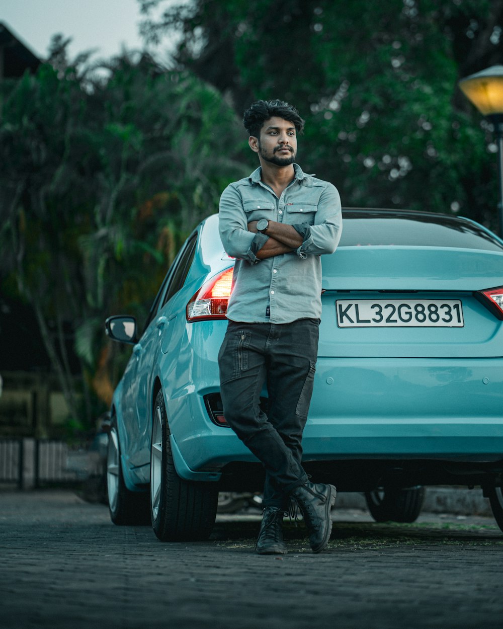 a man standing in front of a blue car