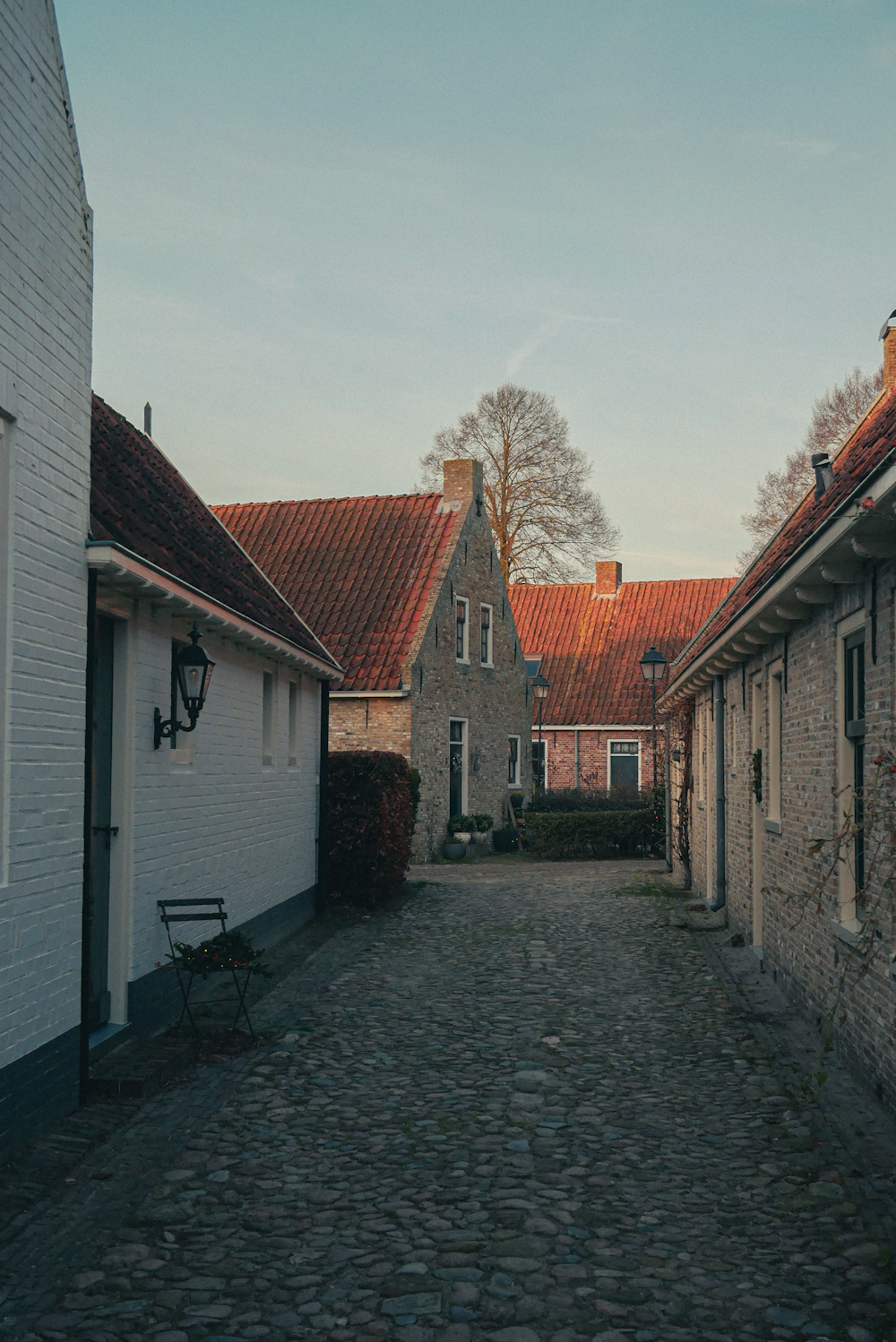 a cobblestone street with a brick building in the background