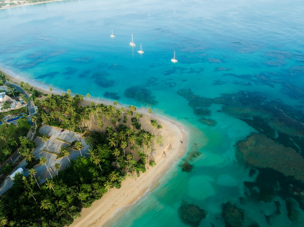 an aerial view of a tropical island with sailboats