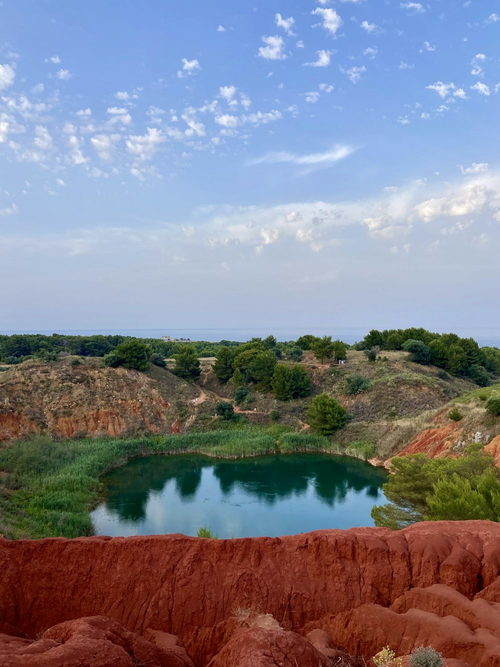 a large body of water surrounded by red rocks