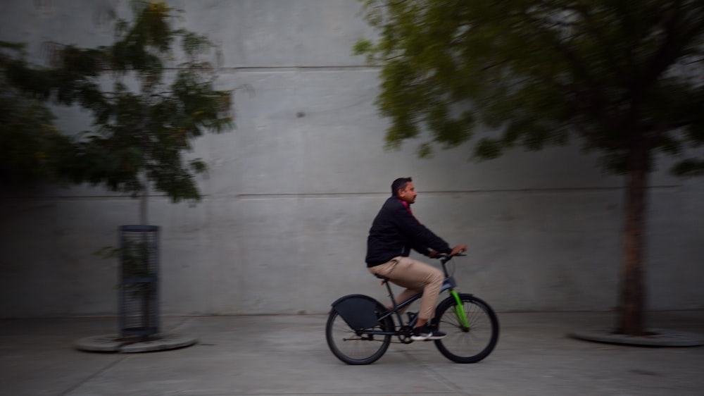 a man riding a bike down a sidewalk