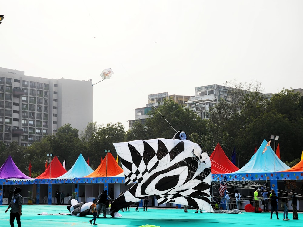 a group of people standing around a large kite