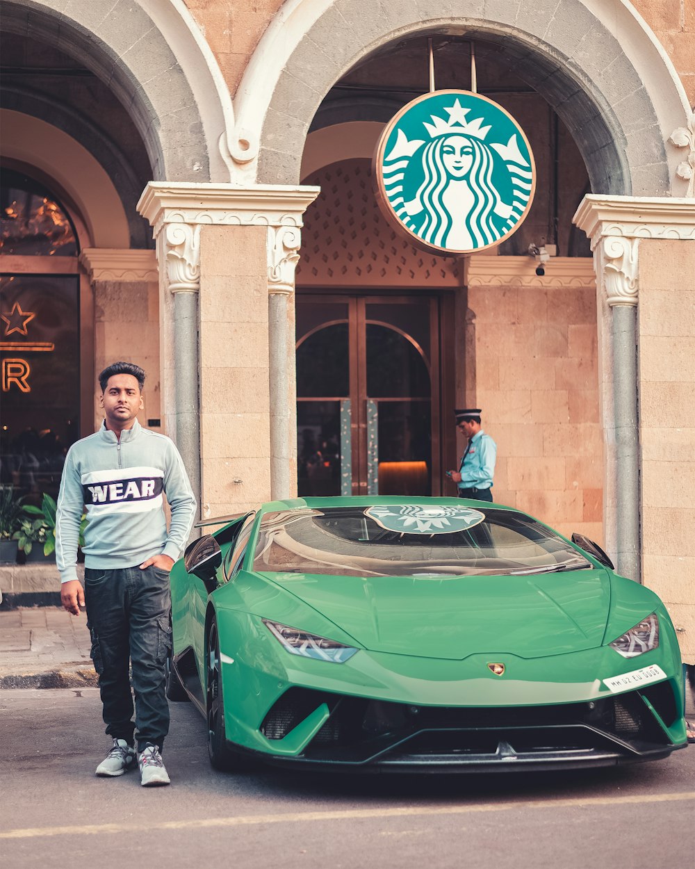 a man standing next to a green sports car