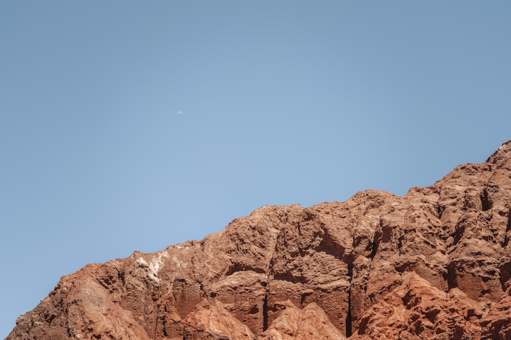 a mountain side with a clear blue sky in the background