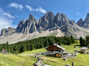 a mountain range with a small cabin in the foreground