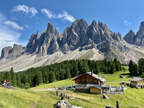 a mountain range with a small cabin in the foreground