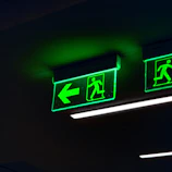 a couple of green signs hanging from the ceiling