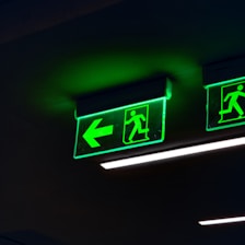 a couple of green signs hanging from the ceiling