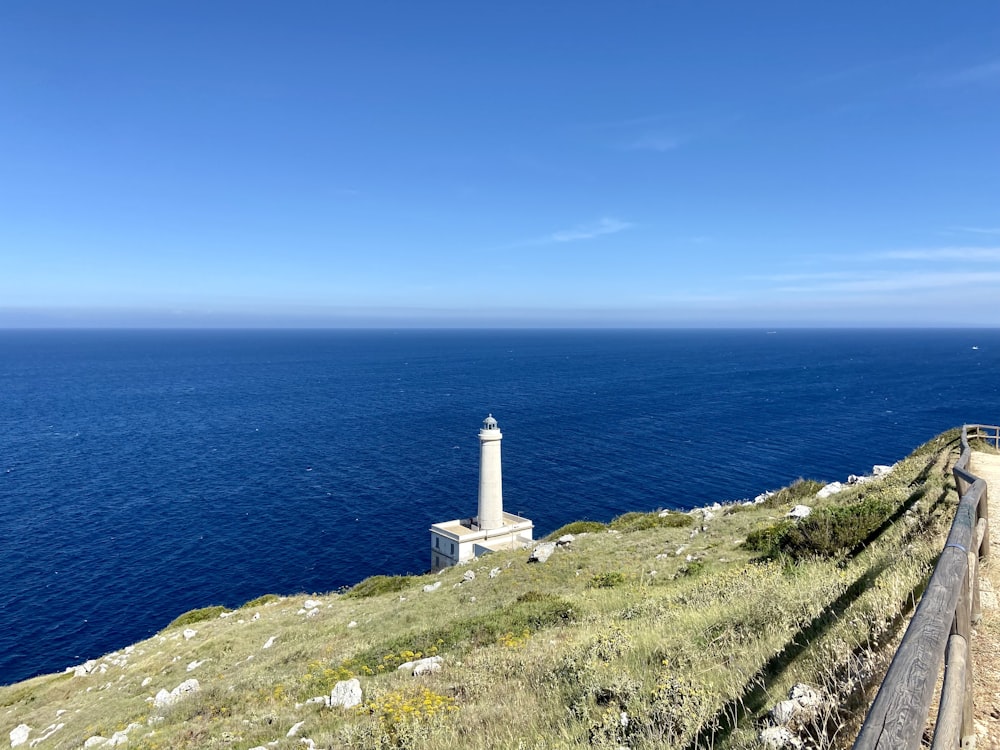 a lighthouse on top of a hill overlooking the ocean