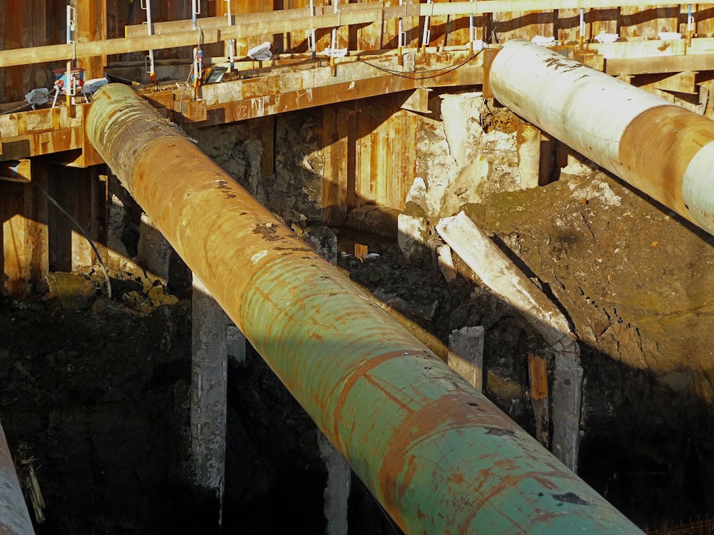 an old rusty pipe on the side of a bridge