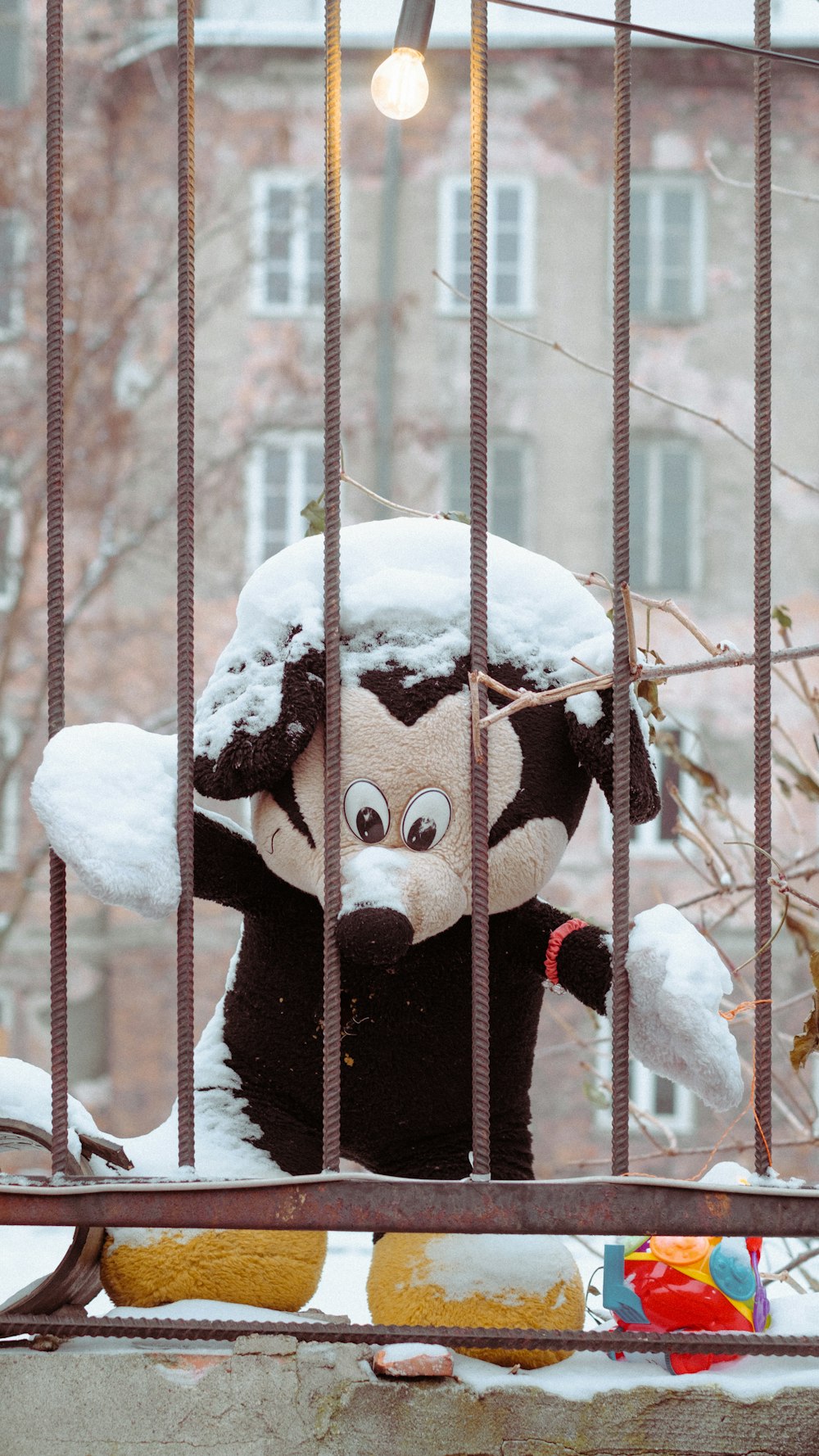 a stuffed animal in a cage with snow on it