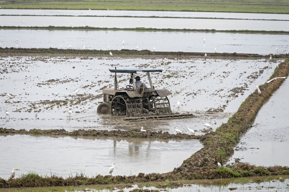 a tractor is driving through a flooded field
