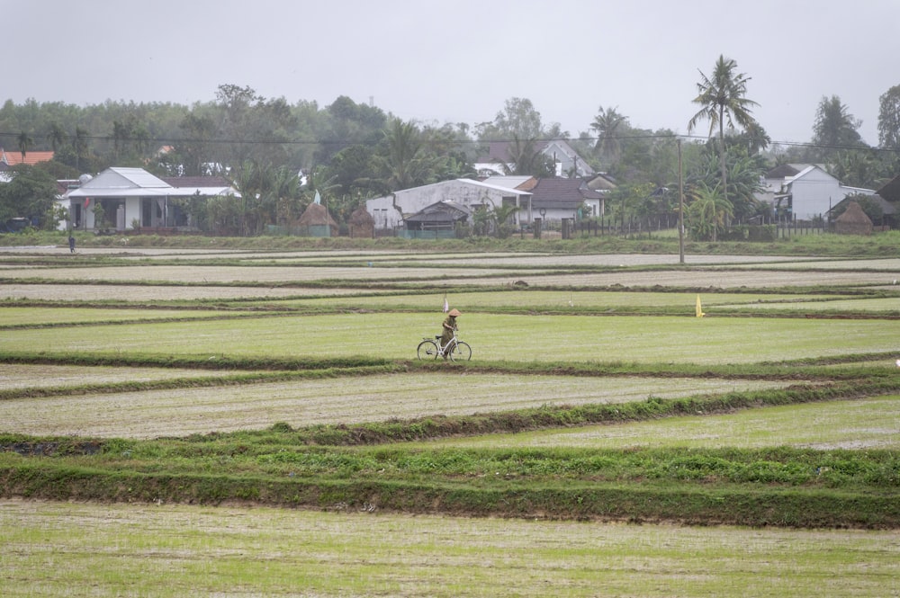 a person riding a bike through a field