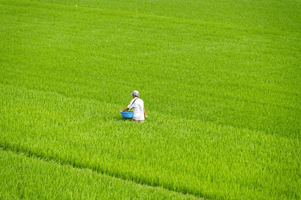 a person in a field with a bucket