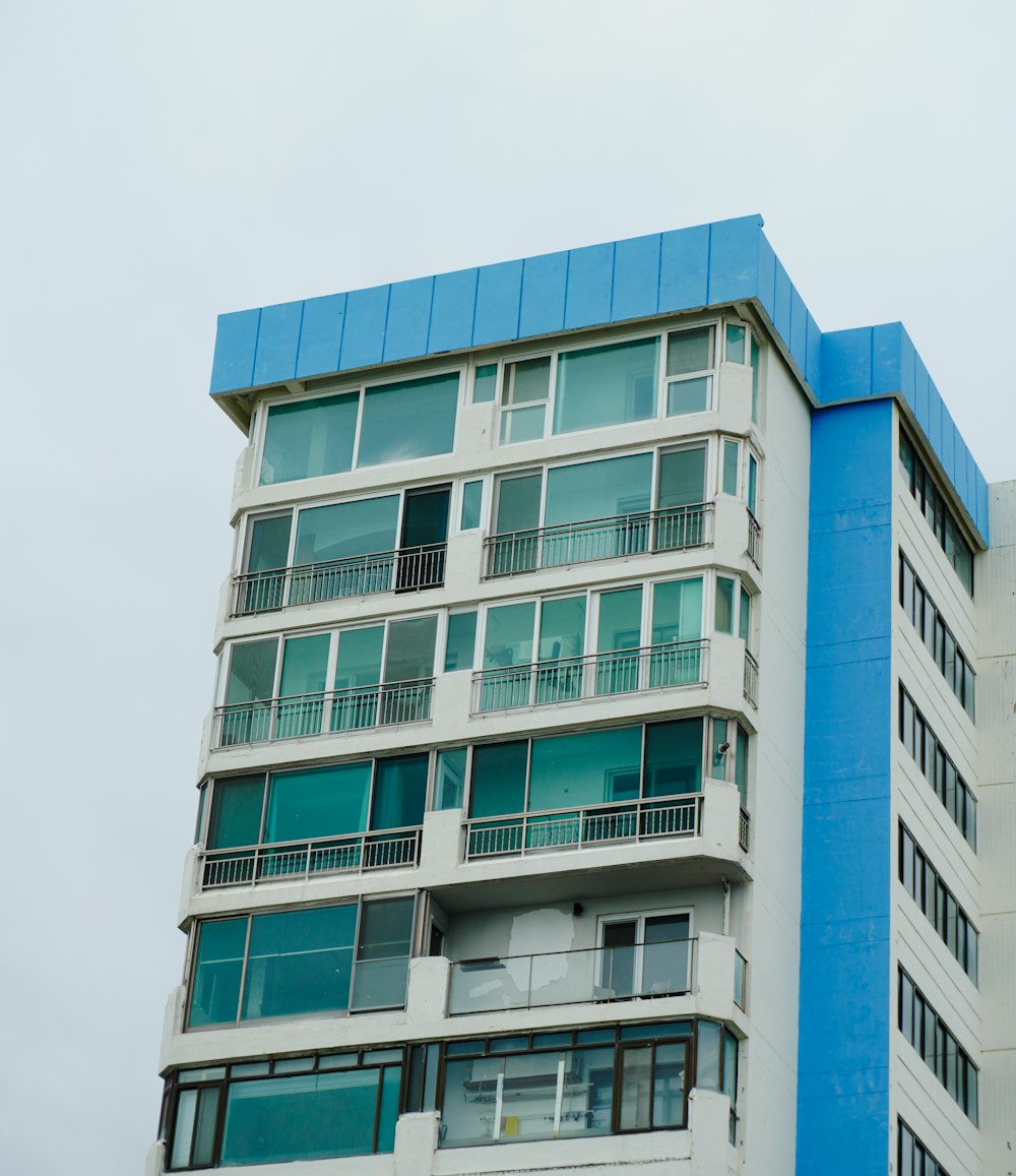 a tall white and blue building with balconies